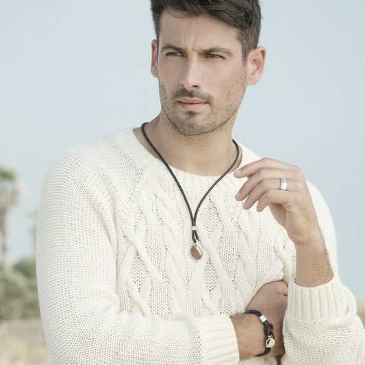 Homem com sueter creme exibindo pulseira prata masculina Topazio 1874 em couro trancado e fecho prata